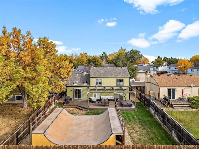 back of house featuring a deck, a fenced backyard, an outdoor hangout area, a yard, and a residential view