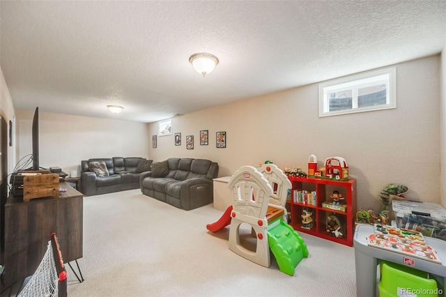 playroom featuring a textured ceiling and carpet flooring