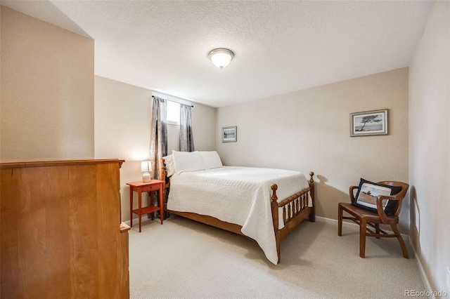 bedroom featuring light carpet, a textured ceiling, and baseboards