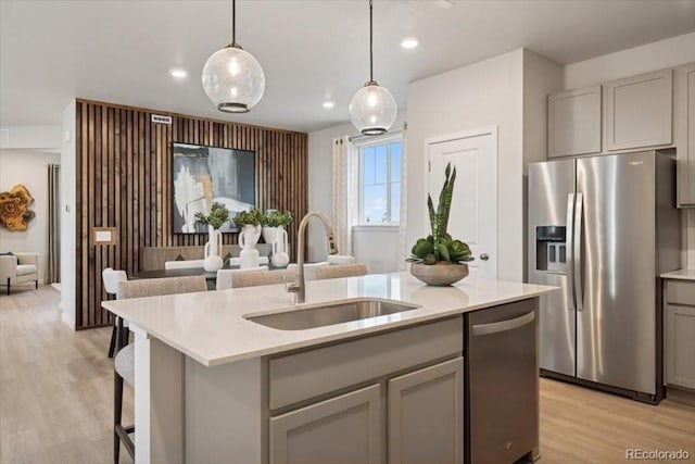 4739 N Valdai Ct, Aurora, CO 80119 - kitchen featuring appliances with stainless steel finishes, gray cabinetry, open floor plan, light wood-style flooring, and light countertops