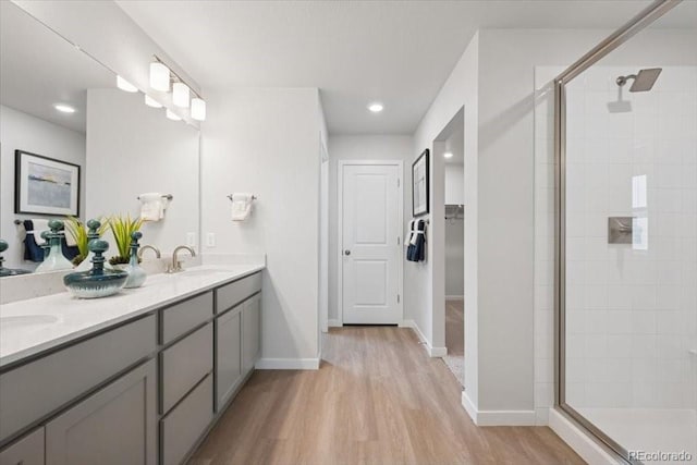 4739 N Valdai Ct, Aurora, CO 80119 - bathroom with a stall shower, wood finished floors, double vanity, a spacious closet, and recessed lighting
