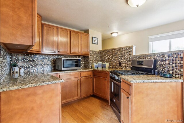 11855 Humboldt Dr, Northglenn, CO 80233 - kitchen with appliances with stainless steel finishes, light wood finished floors, decorative backsplash, and brown cabinets