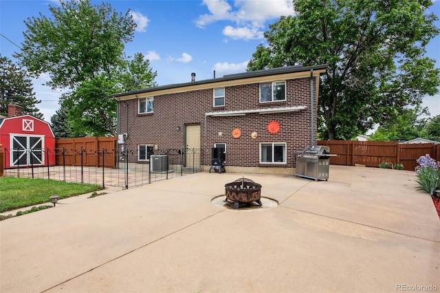 11855 Humboldt Dr, Northglenn, CO 80233 - back of house featuring a patio area, a fire pit, brick siding, a fenced backyard, and a shed