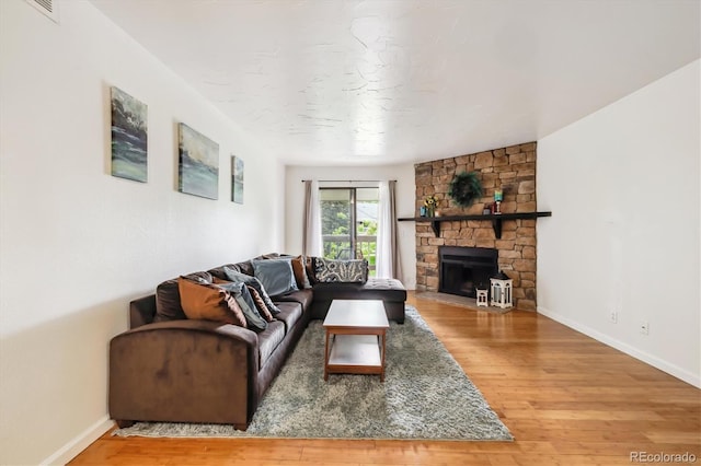 8335 Fairmount Dr Unit 9-201, Denver, CO 80247 - living room with wood finished floors, baseboards, and a stone fireplace