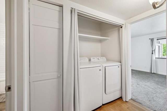 8335 Fairmount Dr Unit 9-201, Denver, CO 80247 - laundry area with independent washer and dryer, light carpet, and light wood finished floors