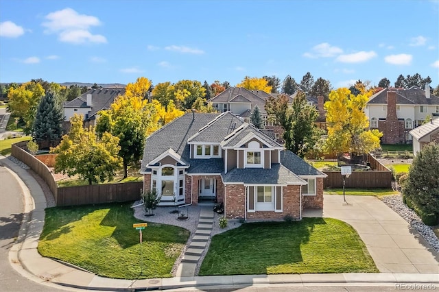 traditional-style home featuring brick siding, fence, and driveway