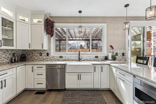 kitchen with a sink, white cabinets, appliances with stainless steel finishes, backsplash, and dark wood-style floors