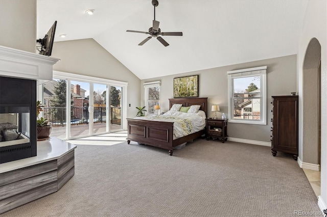 bedroom featuring light carpet, access to outside, multiple windows, and a multi sided fireplace