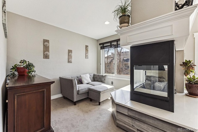 living area featuring light carpet and baseboards