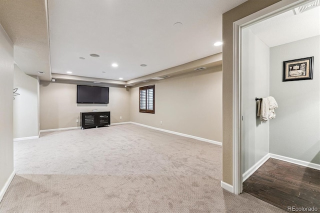 unfurnished living room featuring recessed lighting, carpet flooring, visible vents, baseboards, and a tray ceiling