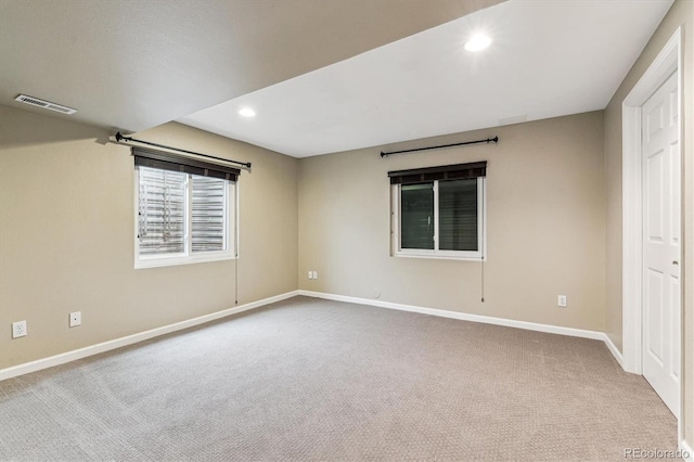 unfurnished room with carpet floors, recessed lighting, visible vents, and baseboards