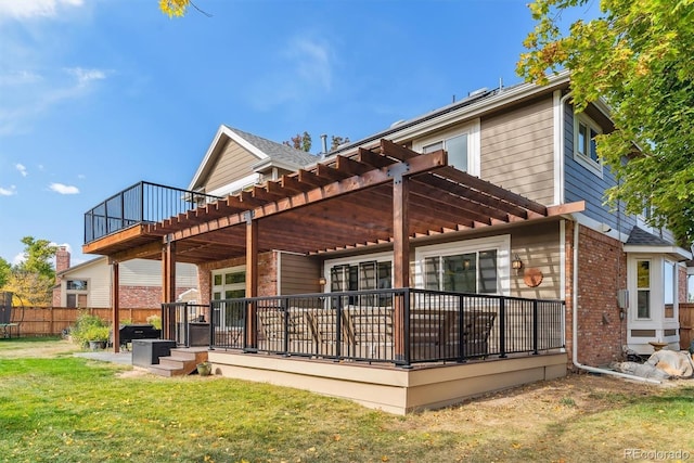 rear view of house featuring brick siding, a yard, fence, a pergola, and a wooden deck