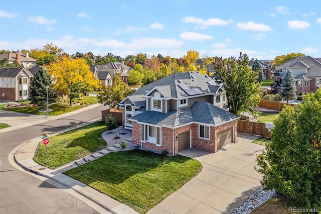 view of front of property with a garage, brick siding, fence, driveway, and a residential view