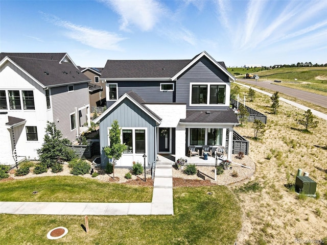 6235 Stable View St, Castle Pines, CO 80108 - back of property featuring board and batten siding, a patio, and a lawn