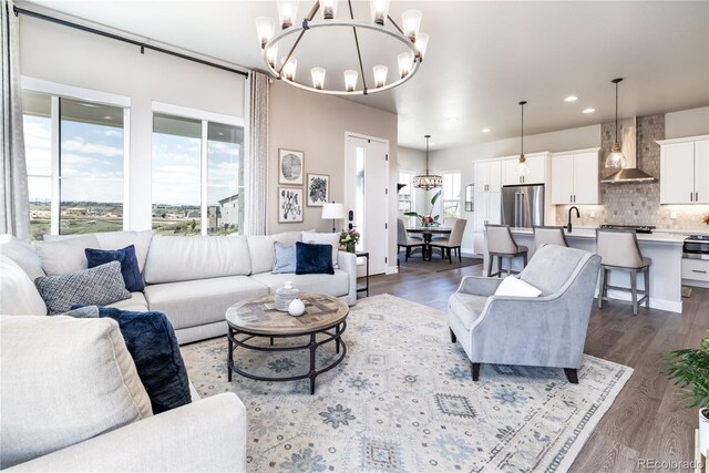 6235 Stable View St, Castle Pines, CO 80108 - living room featuring a chandelier, dark wood-style floors, and recessed lighting