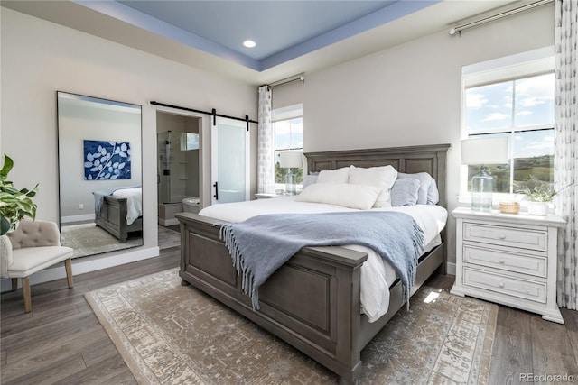 6235 Stable View St, Castle Pines, CO 80108 - bedroom with dark wood-type flooring, a barn door, recessed lighting, and connected bathroom