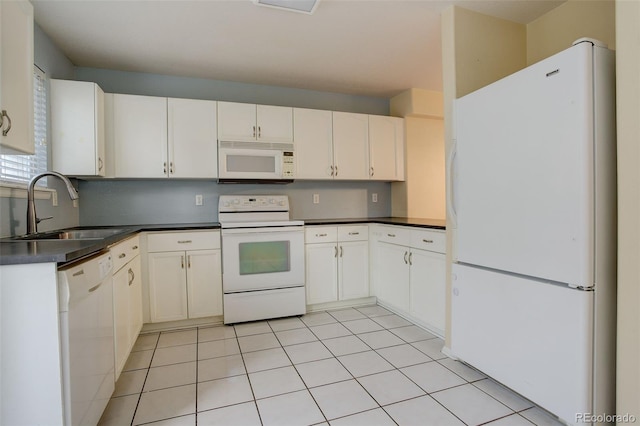 kitchen featuring white appliances, white cabinets, light tile patterned flooring, and sink