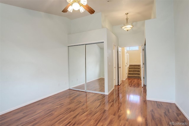 unfurnished bedroom featuring hardwood / wood-style flooring, ceiling fan, and a closet