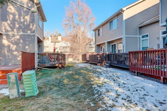 yard layered in snow with a wooden deck