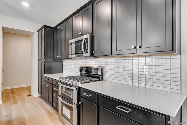 3314 N Haleyville Ct, Aurora, CO 80019 - kitchen with stainless steel appliances, light wood finished floors, light countertops, tasteful backsplash, and baseboards
