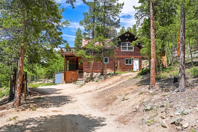 109 Cutforth Rd, Black Hawk, CO 80422 - rustic home with driveway, a wooden deck, and an outbuilding