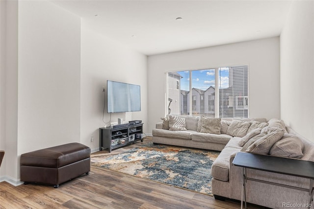 living area with baseboards and wood finished floors