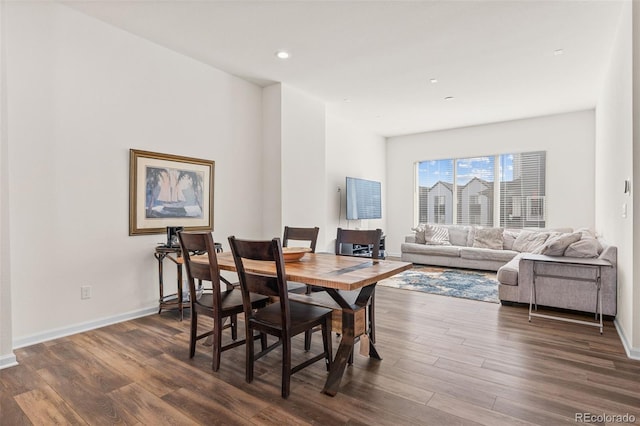 dining room featuring dark wood-type flooring, recessed lighting, and baseboards