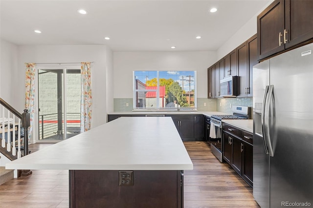 kitchen featuring tasteful backsplash, a kitchen island, appliances with stainless steel finishes, and light countertops