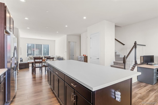 kitchen with a kitchen island, light countertops, and freestanding refrigerator