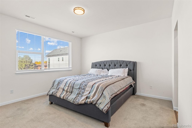 bedroom with baseboards and light colored carpet