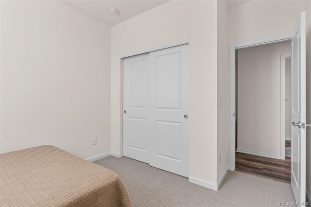 bedroom featuring carpet, baseboards, and a closet