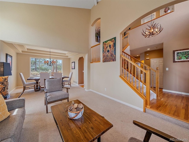 3173 Gold Yarrow Ln, Evergreen, CO 80439 - carpeted living room with stairway, arched walkways, baseboards, a high ceiling, and a notable chandelier