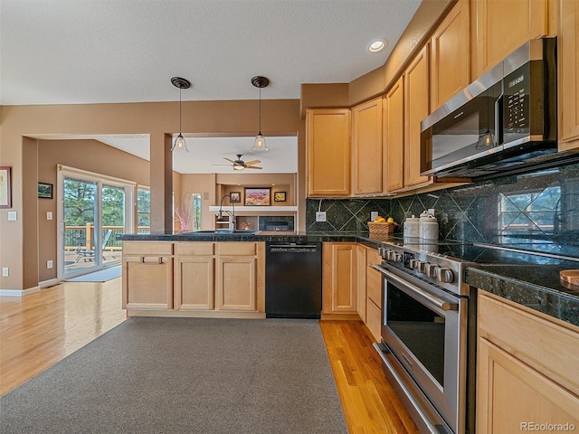 3173 Gold Yarrow Ln, Evergreen, CO 80439 - kitchen with a peninsula, a sink, light wood-style floors, tile counters, and appliances with stainless steel finishes