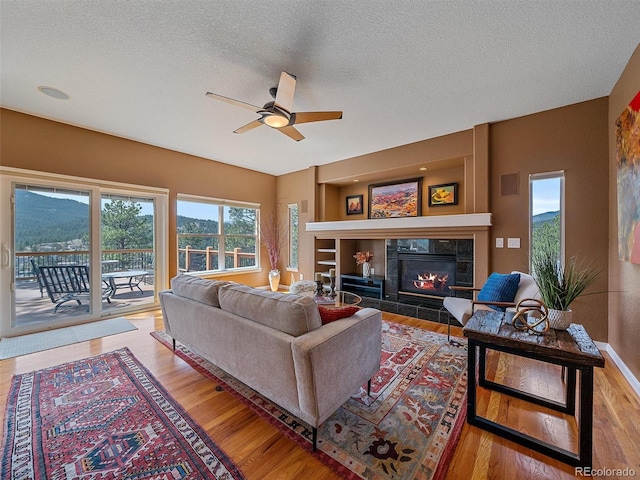 3173 Gold Yarrow Ln, Evergreen, CO 80439 - living area with ceiling fan, wood finished floors, a textured ceiling, and a fireplace