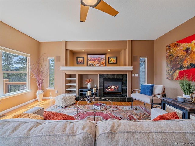 3173 Gold Yarrow Ln, Evergreen, CO 80439 - living room featuring a ceiling fan, wood finished floors, a fireplace, baseboards, and visible vents