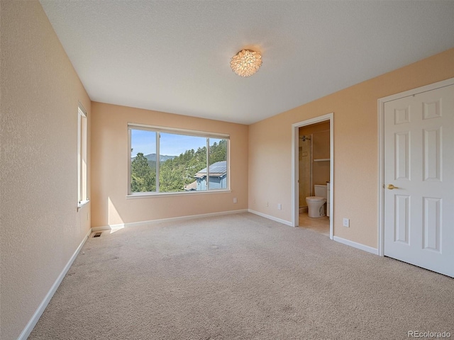 3173 Gold Yarrow Ln, Evergreen, CO 80439 - unfurnished bedroom with carpet, a textured wall, baseboards, ensuite bath, and visible vents