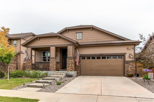 25120 E Maple Pl, Aurora, CO 80018 - craftsman-style house with stone siding, a porch, concrete driveway, and an attached garage