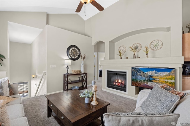 living room with carpet flooring, high vaulted ceiling, visible vents, ceiling fan, and a glass covered fireplace