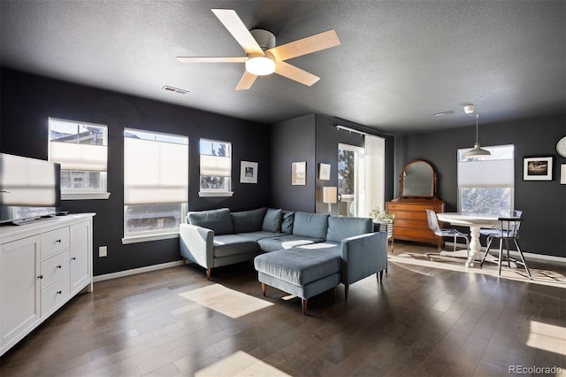 living room featuring plenty of natural light, ceiling fan, and dark hardwood / wood-style flooring