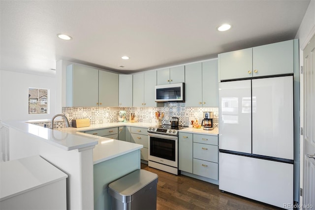 kitchen featuring decorative backsplash, electric stove, dark wood-type flooring, white refrigerator, and a peninsula