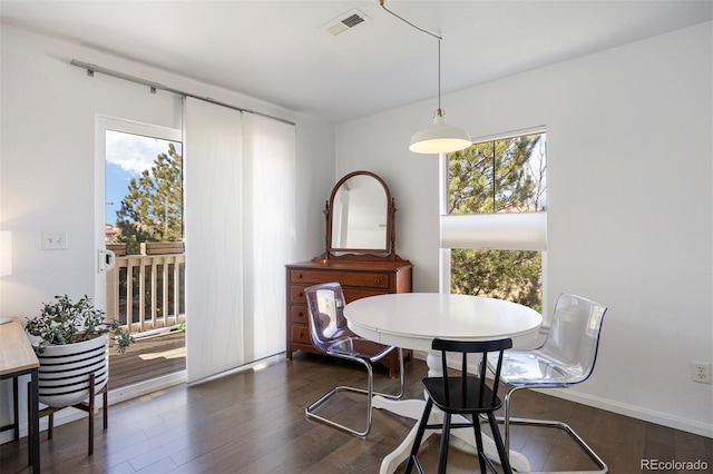 dining room featuring dark wood finished floors, visible vents, and baseboards