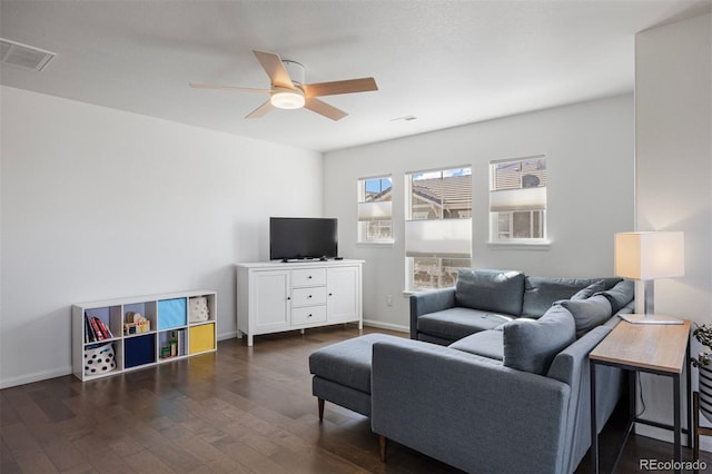 living area with baseboards, ceiling fan, visible vents, and dark wood-type flooring