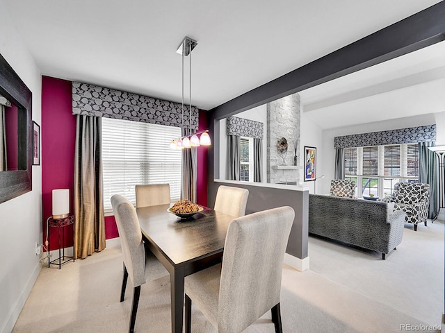 dining room with light colored carpet, baseboards, and vaulted ceiling