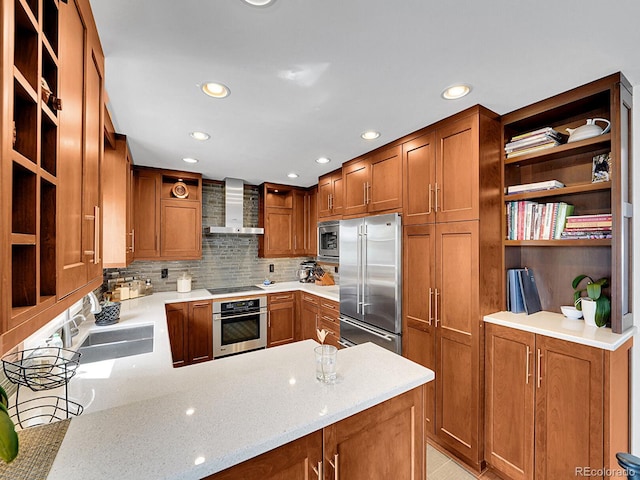 kitchen with wall chimney range hood, open shelves, a sink, a peninsula, and built in appliances