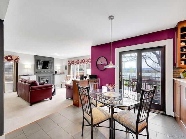dining room with light carpet and a fireplace