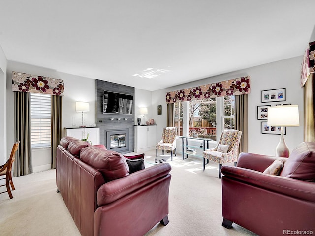 living area with baseboards, light colored carpet, a healthy amount of sunlight, and a fireplace