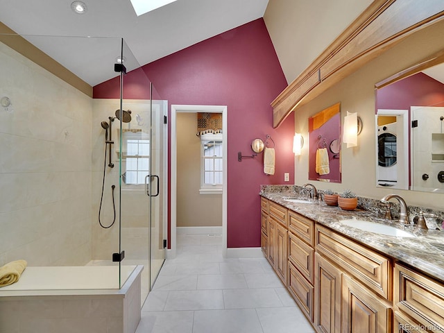 bathroom with double vanity, a sink, lofted ceiling with skylight, and a stall shower