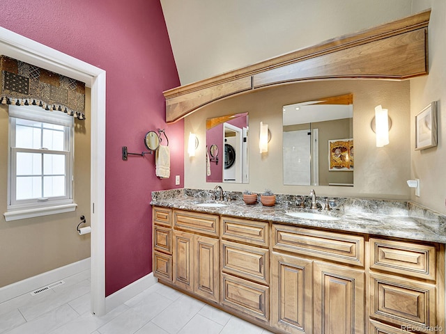 bathroom featuring visible vents, a sink, tile patterned floors, and double vanity
