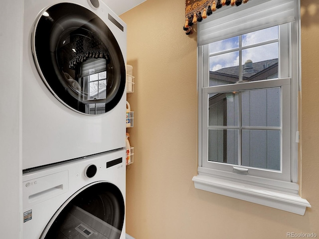clothes washing area with laundry area and stacked washer and dryer