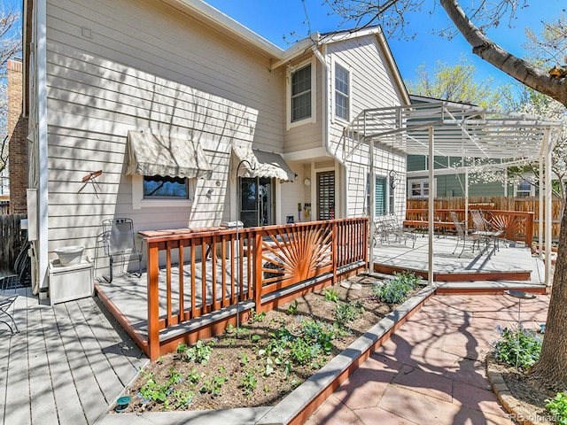 back of property with fence, a pergola, and a deck